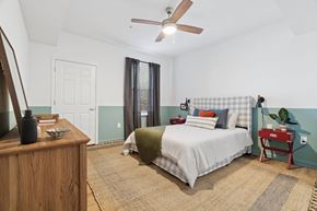 Broomfield apartment for rent - A bedroom with a bed, nightstand, and a fan.