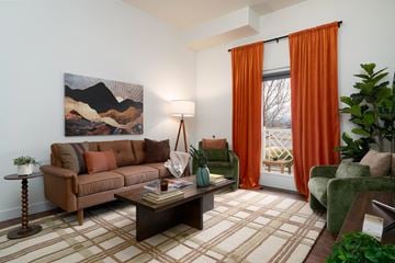 Bozeman apartment for rent - A living room with a brown couch, a coffee table, and a painting on the wall.