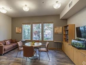 Reno apartment for rent - A living room with a couch, chairs, a table, and a television.