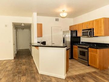 Reno apartment for rent - A kitchen with wooden cabinets and black countertops.