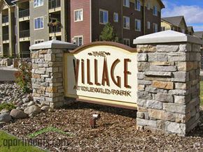 Reno apartment for rent - A sign for The Village at Wildwood Park in front of apartment buildings.