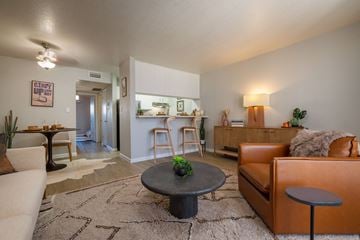 Albuquerque apartment for rent - A living room with a brown leather couch and a round table in the center.