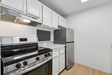 Boise apartment for rent - A modern kitchen with a stainless steel stove and white cabinets.