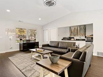 Salt Lake City apartment for rent - A modern living room with a brown leather couch and a wooden coffee table.