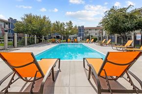 Spokane Valley apartment for rent - A pool surrounded by orange chairs.