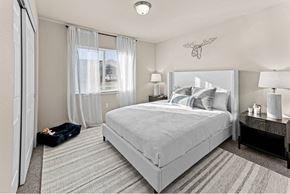 Post Falls apartment for rent - A bedroom with a large bed and a window with curtains at Woodland Meadows Apartments, Post Falls, Idaho