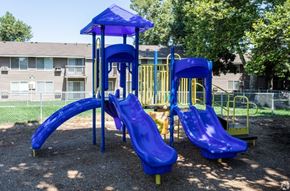 Boise apartment for rent - A playground with a blue slide and a yellow slide.