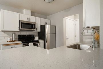 Boise apartment for rent - A kitchen with white cabinets and a granite countertop.