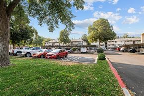 Boise apartment for rent - A parking lot with cars and trees.