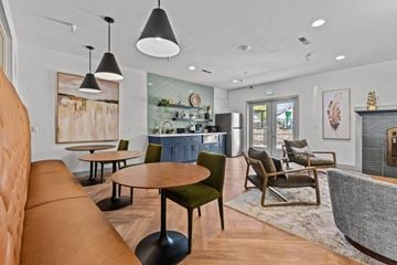 Boise apartment for rent - A modern living room with a brown leather sofa and a green chair.