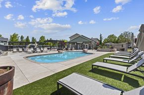 Boise apartment for rent - A pool area with sun loungers and a building in the background.