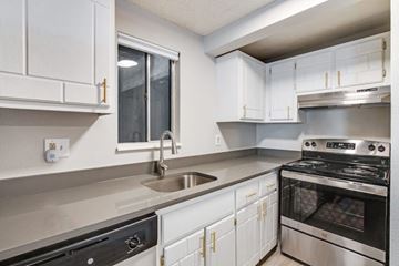 Fort Collins apartment for rent - A modern kitchen with white cabinets and stainless steel appliances.