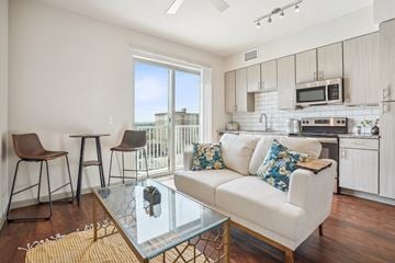 Denver apartment for rent - A modern living room with a white couch and a glass coffee table.