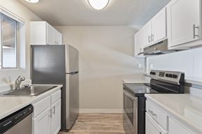 Spokane Valley apartment for rent - A kitchen with white cabinets and black appliances.