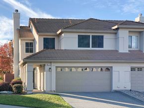 Vacaville apartment for rent - A two-story house with a white garage door.