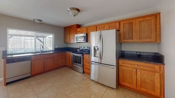 Vacaville apartment for rent - A kitchen with wooden cabinets and a black countertop.