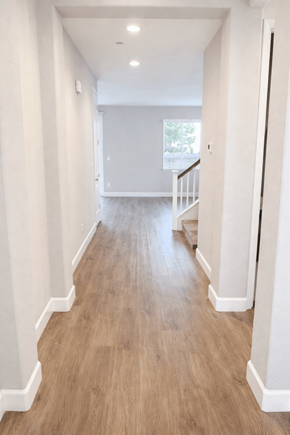 Chico house for rent - A long hallway with wood floors and white walls.