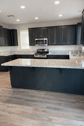 Chico house for rent - A modern kitchen with a large island and dark cabinets.