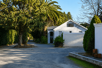 Concord apartment for rent - A white house with a driveway and trees surrounding it.
