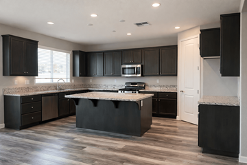 Chico apartment for rent - A kitchen with black cabinets and a granite countertop.