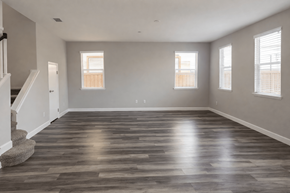 Chico apartment for rent - A spacious room with wooden flooring and three windows.