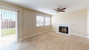 Suisun City house for rent - A living room with a fireplace and a ceiling fan.