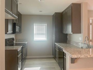 Bay Point apartment for rent - A kitchen with brown cabinets and granite countertops.