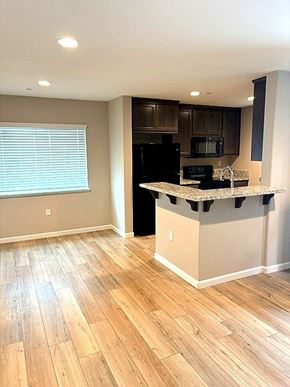Bay Point apartment for rent - A kitchen with a black refrigerator and wooden floors.