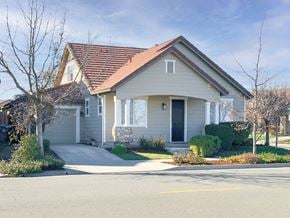 Fairfield apartment for rent - A house with a grey facade and a red roof is surrounded by a well-maintained lawn and a clear sky.