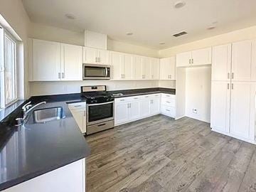 Chico apartment for rent - A kitchen with white cabinets and a black countertop.