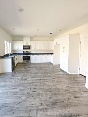 Chico apartment for rent - A kitchen with white cabinets and a black stove top oven.