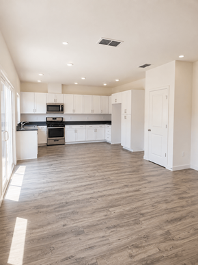 Chico apartment for rent - A kitchen with white cabinets and a wooden floor.