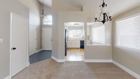 Pittsburg apartment for rent - A large open room with a carpeted floor and a chandelier hanging from the ceiling.