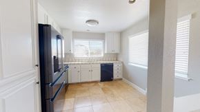 Pittsburg apartment for rent - A kitchen with a black fridge and white cabinets.