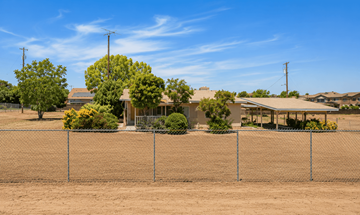 Oakley apartment for rent - A fenced area with a house and trees in the background.