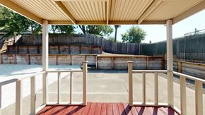 Vacaville apartment for rent - A wooden deck with a red floor and a white railing.