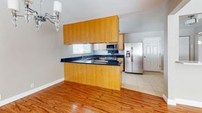 Vacaville apartment for rent - A kitchen with wooden cabinets and a black countertop.