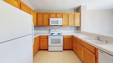 Bay Point apartment for rent - A kitchen with wooden cabinets and white appliances.
