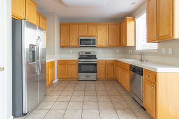 Pittsburg apartment for rent - A kitchen with wooden cabinets and a refrigerator.