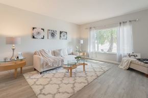 Pittsburg apartment for rent - A living room with a white sofa, a glass coffee table, and a rug.