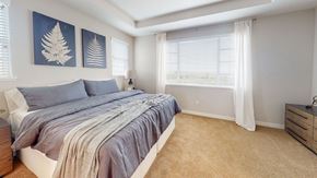Fairfield apartment for rent - A bedroom with a bed, two wall art pieces, a nightstand, and a window with curtains.