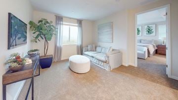 Fairfield apartment for rent - A living room with a white couch and a round ottoman.