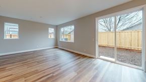 Chico apartment for rent - A room with wooden floors and white walls, with a view of a wooden fence outside.
