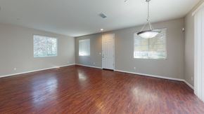 Suisun City apartment for rent - A room with wooden floors and a hanging light fixture.