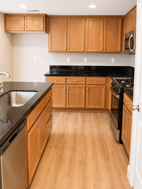 Chico house for rent - A kitchen with wooden cabinets and black countertops.