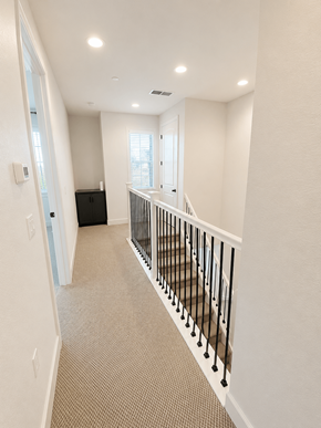 Martinez townhouse for rent - A hallway with a carpeted floor and a black railing.