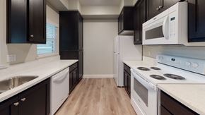Chico apartment for rent - a kitchen with white appliances and black cabinets at Heritage Landing Apartments, Chico, CA