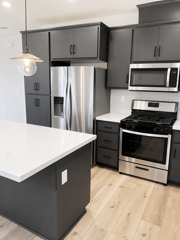 Martinez townhouse for rent - A kitchen with black cabinets and a white countertop.
