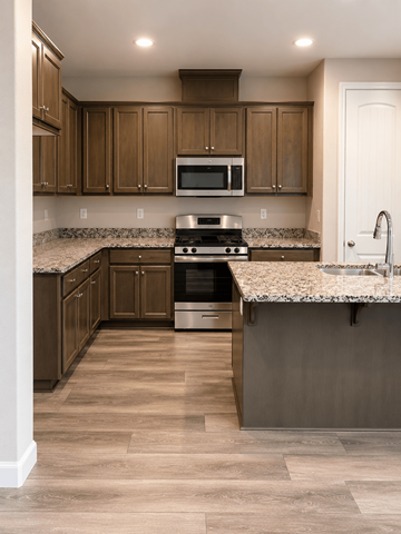 Chico apartment for rent - A kitchen with wooden cabinets and a granite countertop.