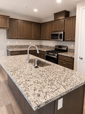 Chico apartment for rent - A kitchen with granite countertops and wooden cabinets.